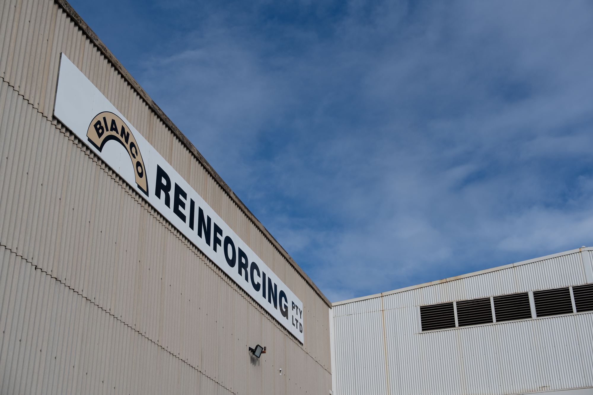 Bianco Reinforcing sign on the Gepps Cross building against a blue sky